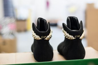 Black suede sneakers with custom gold accessory
