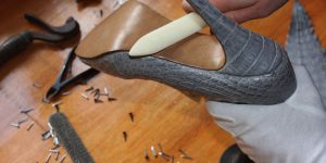 Artisan finishing the custom shoe with the outsole polish