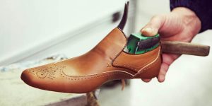Artisan holding men's formal custom shoe