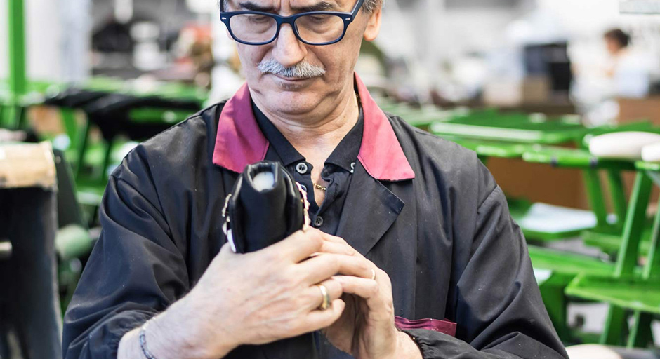 Shoemaker performing quality control of custom shoes