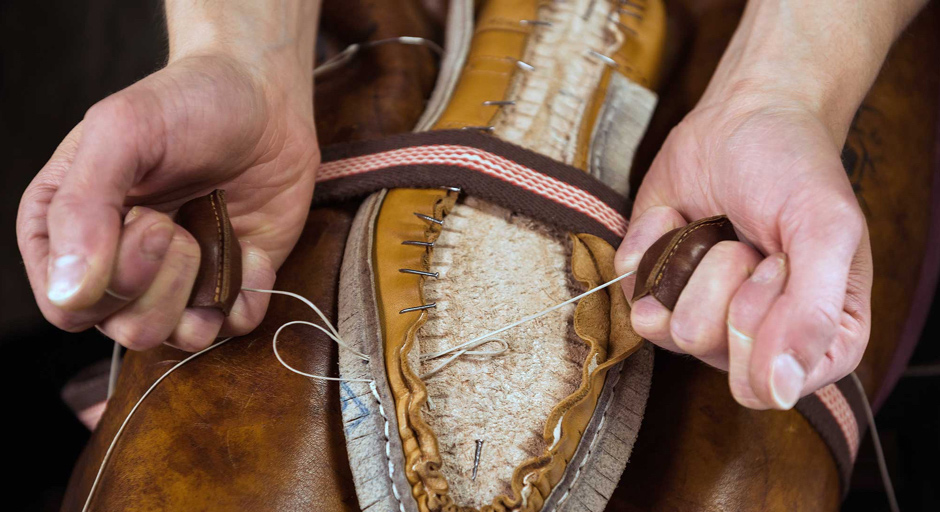 Artisan stitching the custom shoe last and leather insole