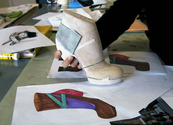 Artisan holding shoe last for private label shoes